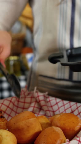personal femenino arreglando croissants horneados en la canasta en la sección de panadería