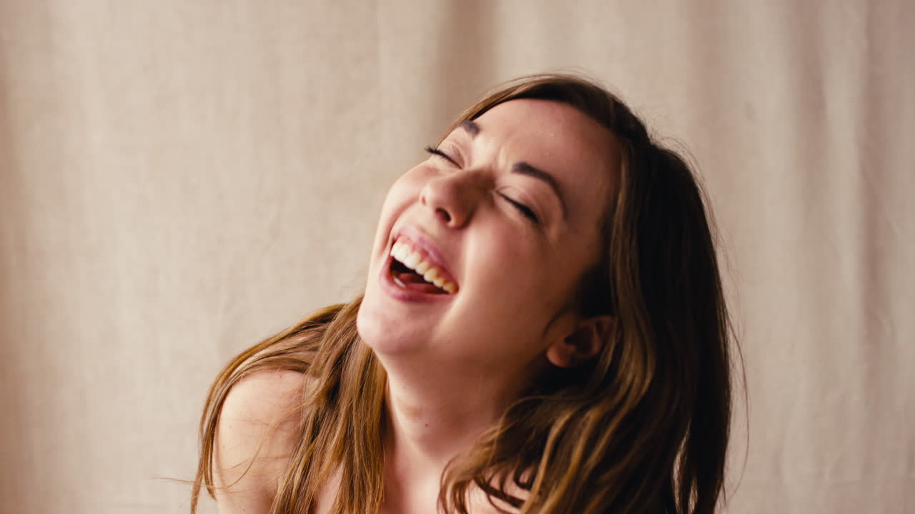 fotografía de estudio de una mujer natural y segura en ropa interior que promueve la positividad corporal riendo