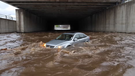 car trapped in floodwaters under an underpass
