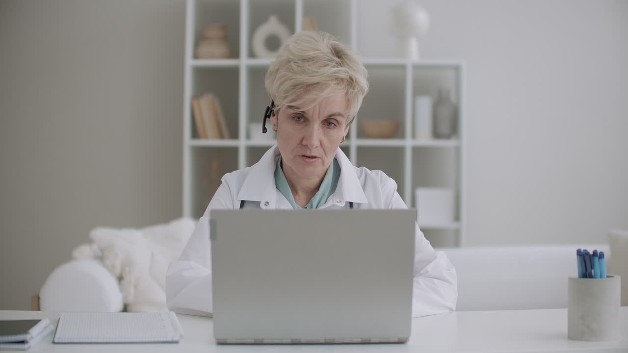 el médico se está comunicando en línea con colegas mujeres, pacientes o pasantes por ordenador portátil utilizando la tecnología de videollamada o videochat