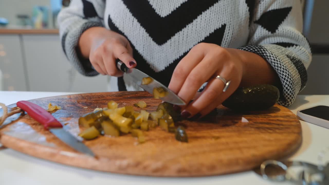 Woman cutting pickles on a wooden board