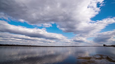 paisaje fluvial natural 4k hd alta definición reflejo acelerando en el nivel del agua de las nubes. reflejo de fondo de las nube en el agua ondulante. paisaje relajante escénico en un día claro de verano. bucle