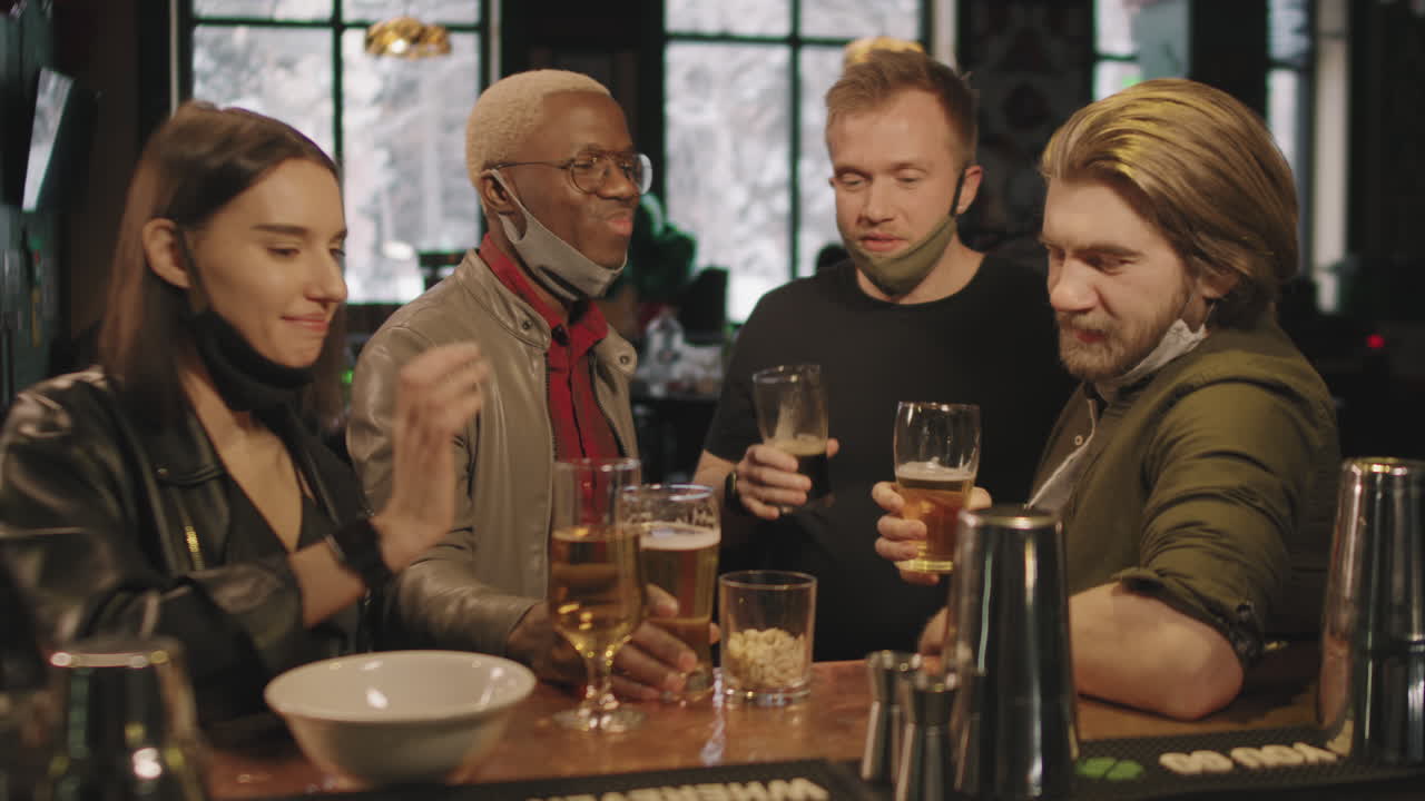 Amici che brindano con bicchieri di birra al bar
