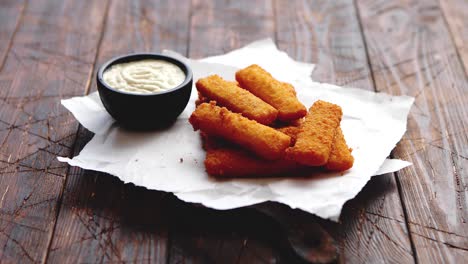 Pila-De-Palitos-De-Pescado-Fritos-Dorados-Con-Salsa-De-Ajo-Blanco