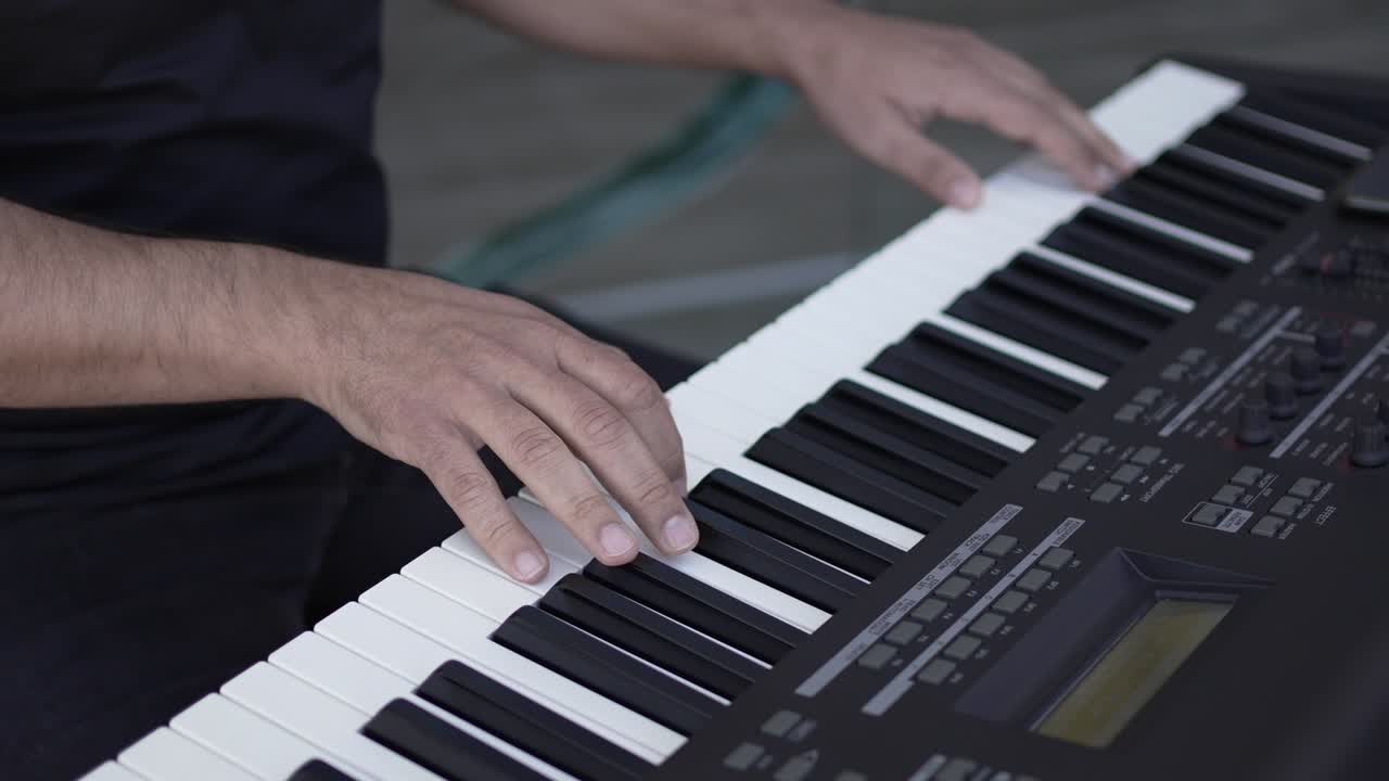 primer plano de las manos tocando hábilmente un teclado electrónico, haciendo hincapié en el arte musical