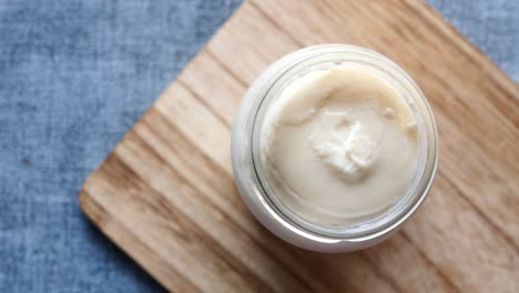 un frasco de yogur en una tabla de cortar de madera