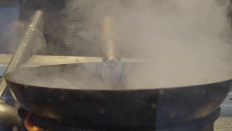 close-up of a steaming wok on a stove