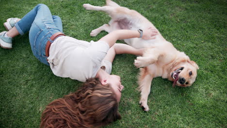 woman playing with her dog on the grass