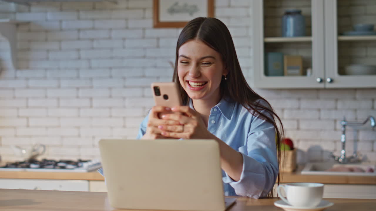 Woman winner checking smartphone notification at computer table remote closeup