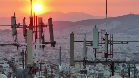 aerial - close shot of building antennas with athens skyline in the background