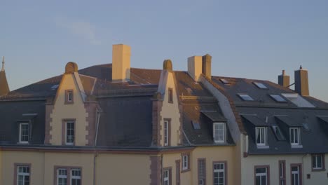 sunset view of a traditional building rooftop, capturing architecture and chimneys.