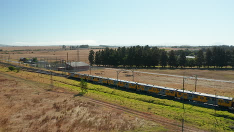 train in stellenbosch passing by rural fields at summer in south africa