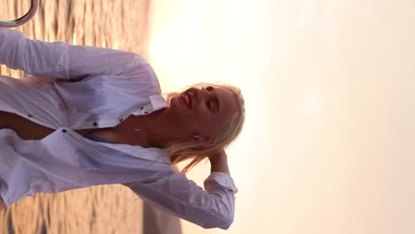 retrato de una mujer rubia con una camisa blanca posando en un velero en el mar adriático durante la puesta de sol en dubrovnik, croacia