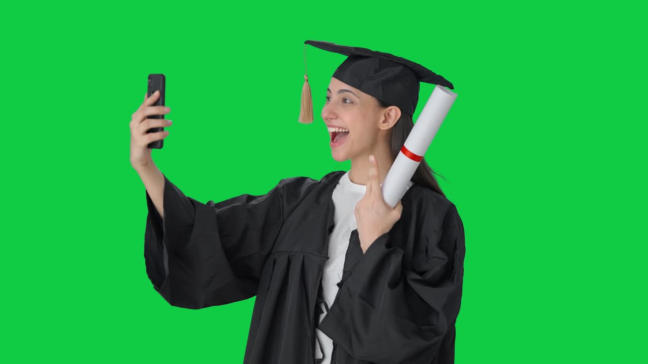 Felice ragazza indiana laureata che si scatta selfie su green screen