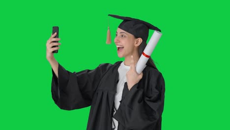 feliz chica graduada de la universidad india haciendo clic en selfies pantalla verde