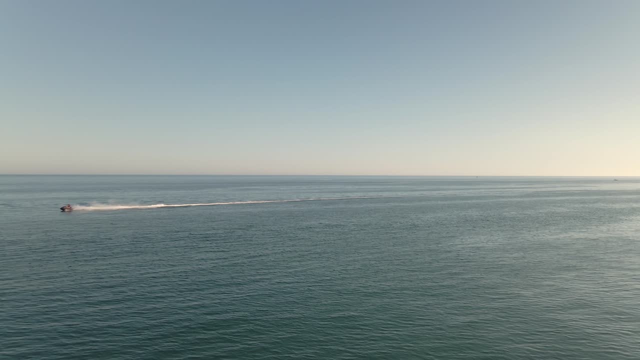 vista aérea rápida acelerando la moto de agua a través del horizonte del océano marino de derecha a izquierda