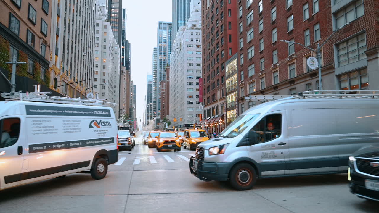 New York, USA, 8. oktober 2025: Manhattan Street Traffic. Urbant gadebillede på Manhattan med varevogne, taxaer og fodgængere i aftenbelysning
