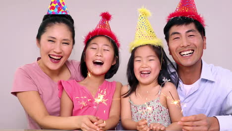 happy family celebrating a birthday and holding sparklers