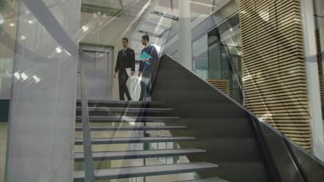 Animation-of-escalators-over-business-people-talking-in-modern-office