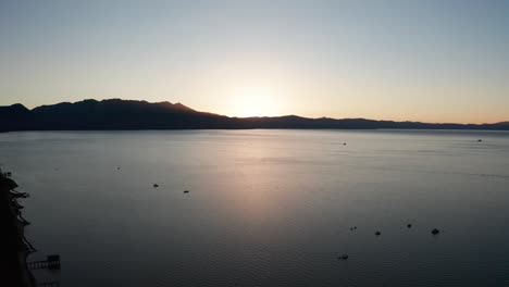 Reverse-pullback-aerial-shot-of-Lake-Tahoe-at-sunset-in-the-summer