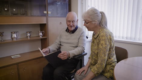 elderly couple looking at album