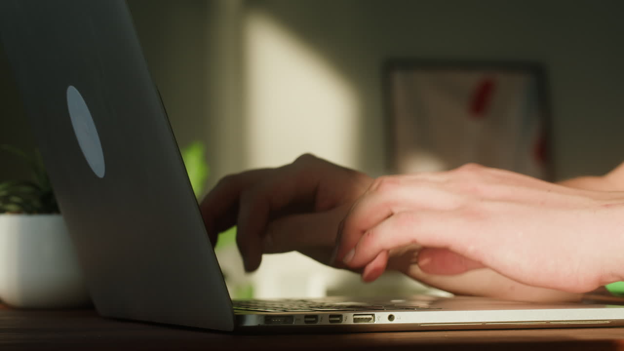 Close-up of Hands Typing on a Laptop Keyboard