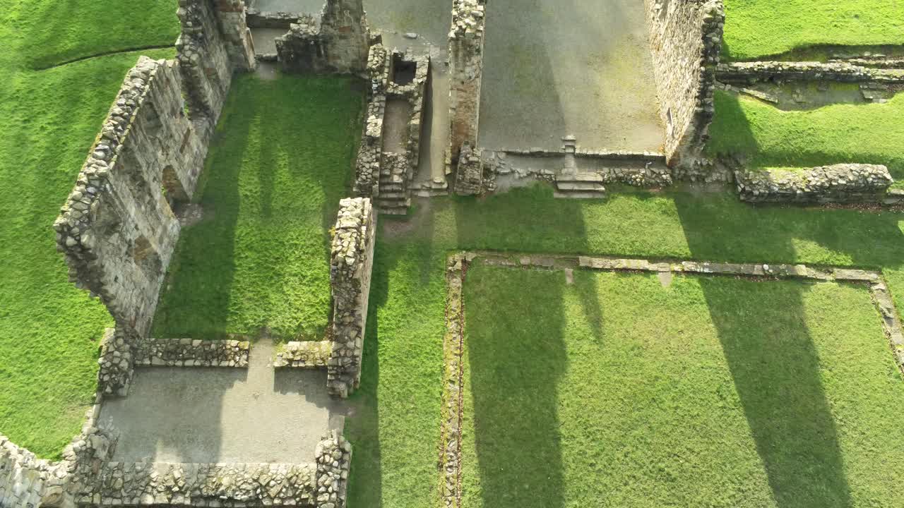 Abbazia di Basingwerk, punto di riferimento, rovine medievali gallesi abbandonate, vista aerea in elevazione con inclinazione verso il basso