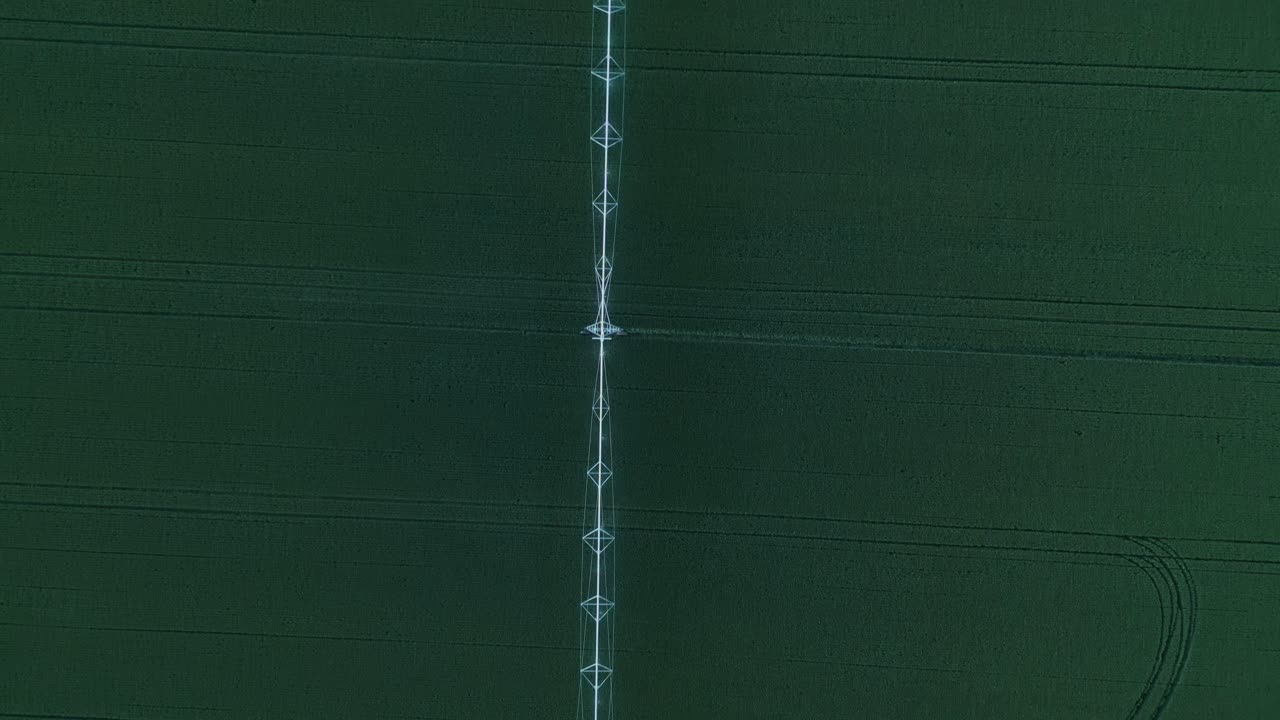 Above View Of Automatic Sprinkler Irrigation In Vast Green Fields. Aerial Topdown Shot
