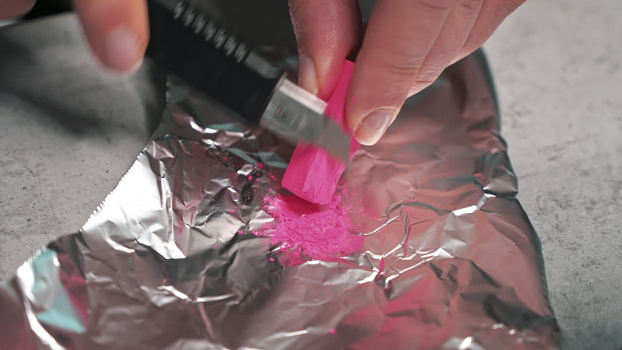 Hand made candles production, woman preparing a pink dye for wax
