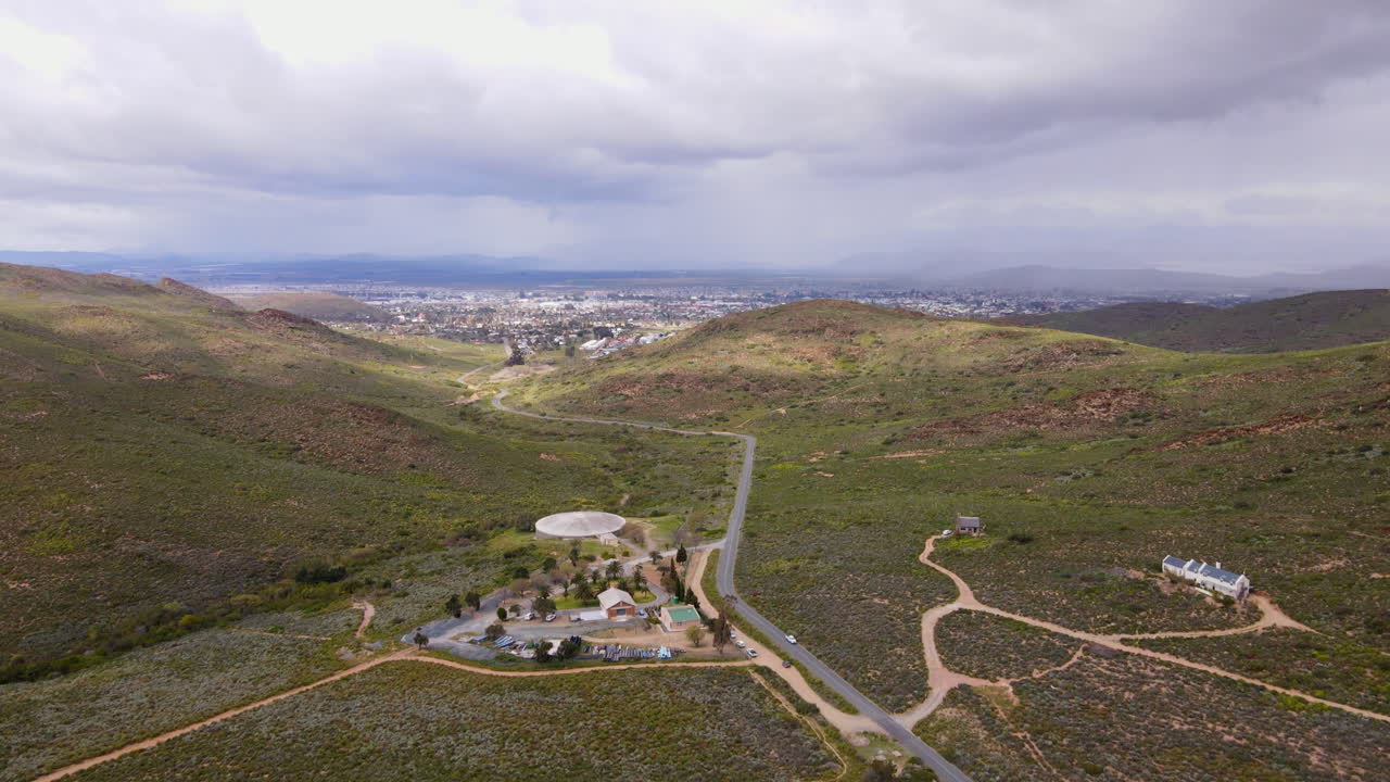 Aerial tilt-up over semi-desert vegetation reveals city of Worcester, RSA
