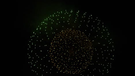 fireworks explode into round ball in dark night sky, festive celebration
