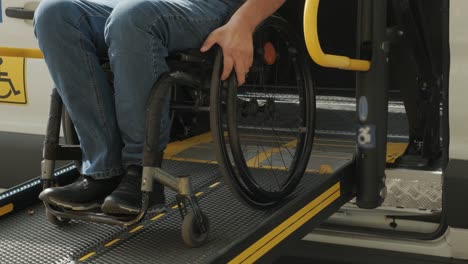 a man in a wheelchair on a lift of a vehicle for people with disabilities. lifting equipment for people with disabilities - man in wheelchair near the vehicle