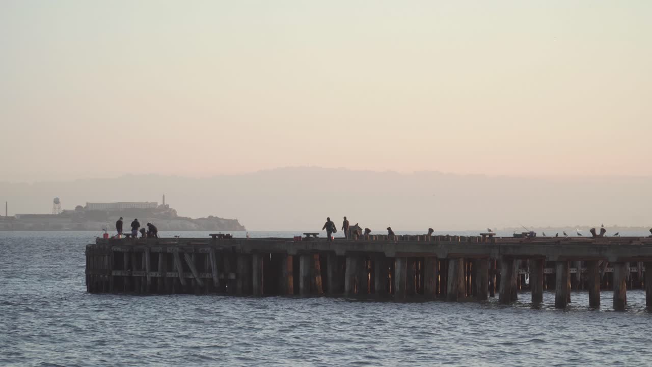 고요한 아침에 만의 부두에서 낚시하는 어부들