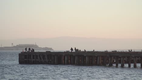 pescadores pescando en un muelle en la bahía en una mañana tranquila
