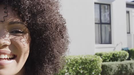 retrato de una feliz mujer afroamericana sonriendo en el jardín, espacio de copia, cámara lenta