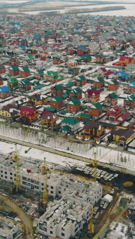construction in progress site on weekend against residential complex with houses and infrastructure bird eye view
