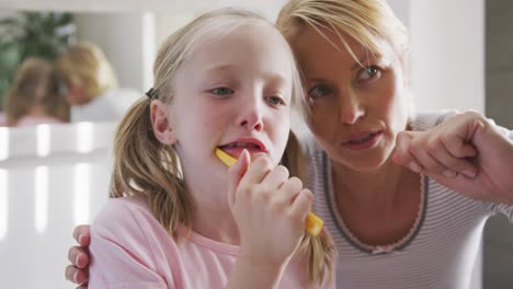 Seitenansicht-Eines-Kaukasischen-Mädchens,-Das-Sich-Die-Zähne-Putzt-Und-Von-Seiner-Mutter-Beraten-Wird