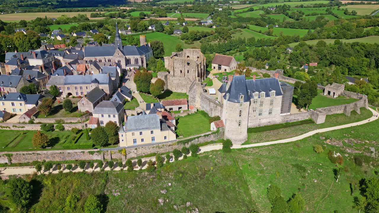 Medieval castle and town of Sainte-Suzanne rise over Mayenne’s green hills, with ramparts, towers, and scenic viewpoints, panoramic drone panning