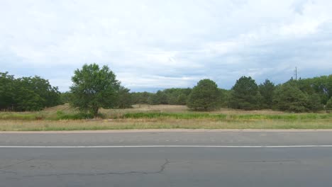 trees and fields as well as rural homes race by in this "out of the window" look at america