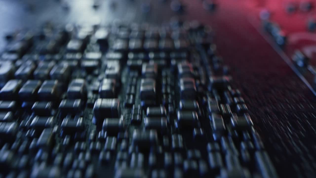 cámara macro moviéndose lentamente sobre la placa de circuitos impresos, mostrando los componentes de la placa base de la computadora: transistores, resistores, condensadores, semiconductores. dentro del dispositivo electrónico. colores de neón rojo