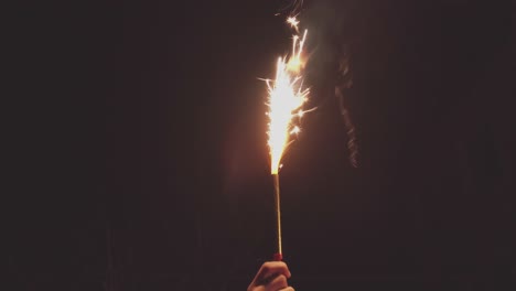 festive christmas roman candle sparkler in hand in the night, vintage toning slow motion