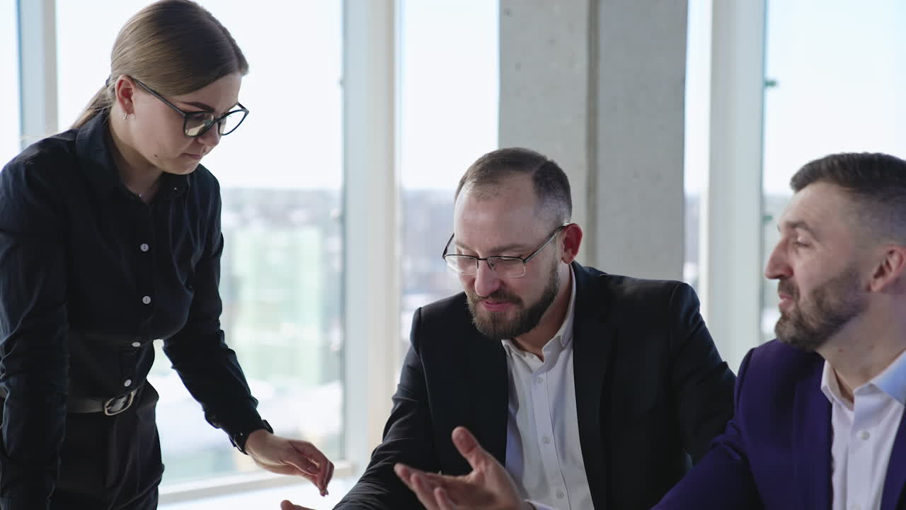 Two men and a woman in the office discussing work. Colleagues meeting and searching solutions and strategies. Close up.