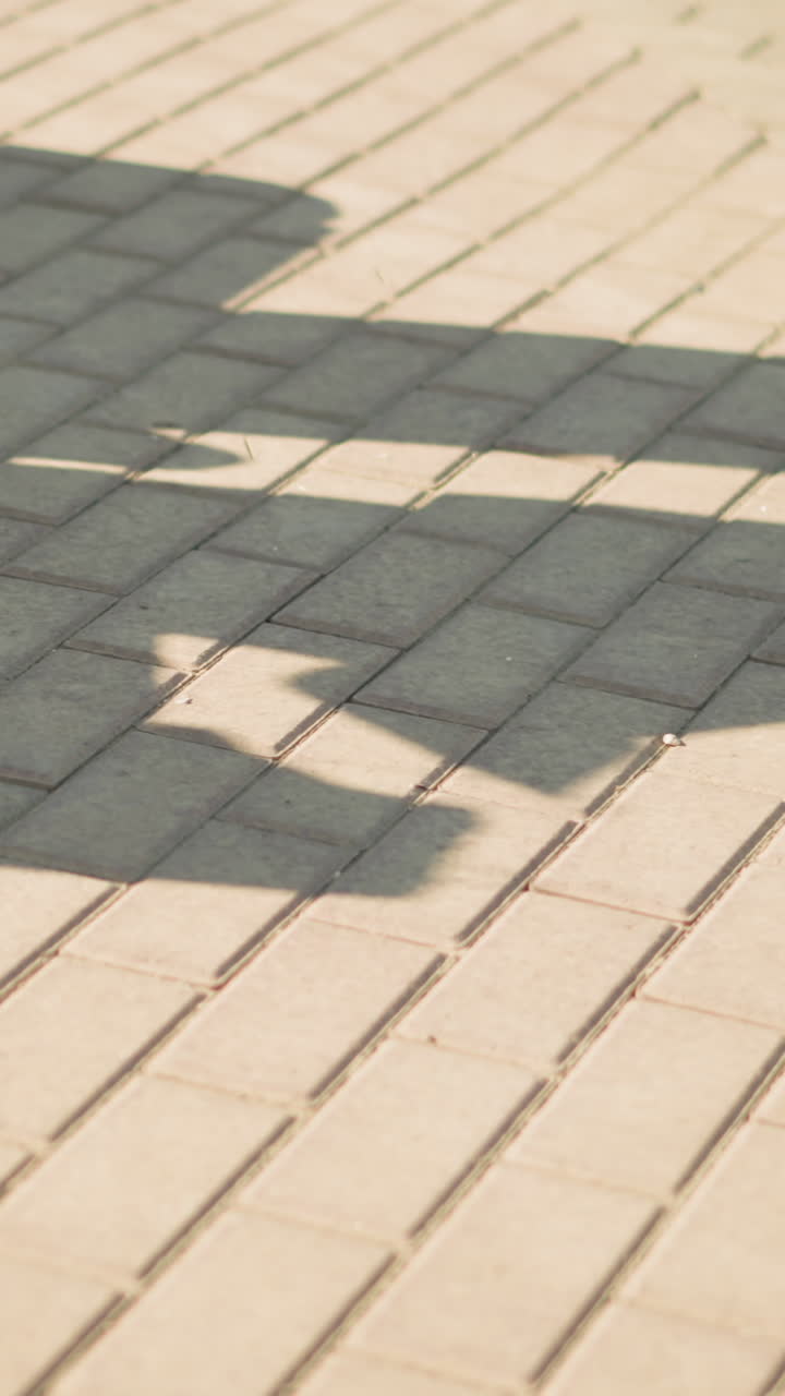 회색 조과 색 캔버스 신발을 입고 앉아있는 사람의 다리 시야, 인 바닥에 던진 그림자, 개인의 그림자는 개인이하는 것을 반영합니다.