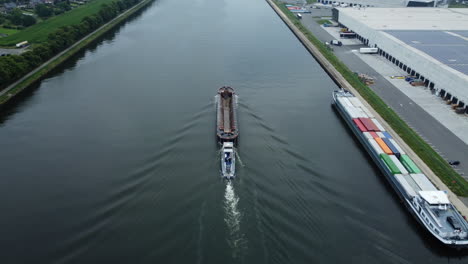 canal shipping with barge and tugboat, industrial landscape