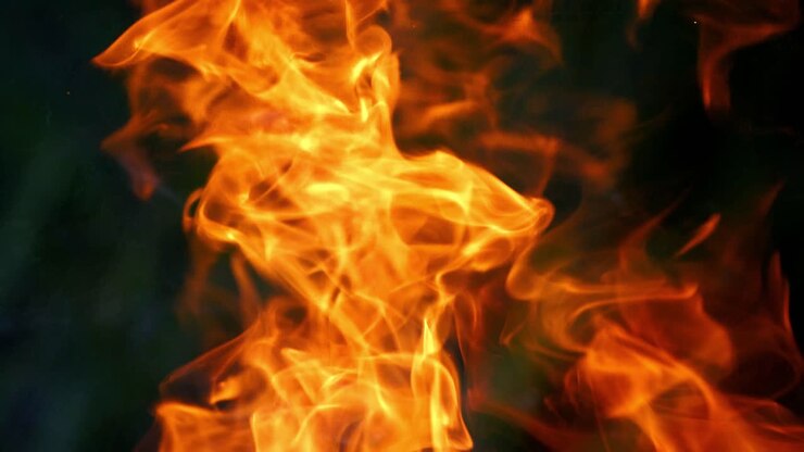 Legna da ardere bruciata in un falò. Fuoco di un falò all'aperto in primo piano.