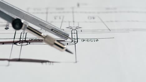 a drafting compass on an engineering blueprint