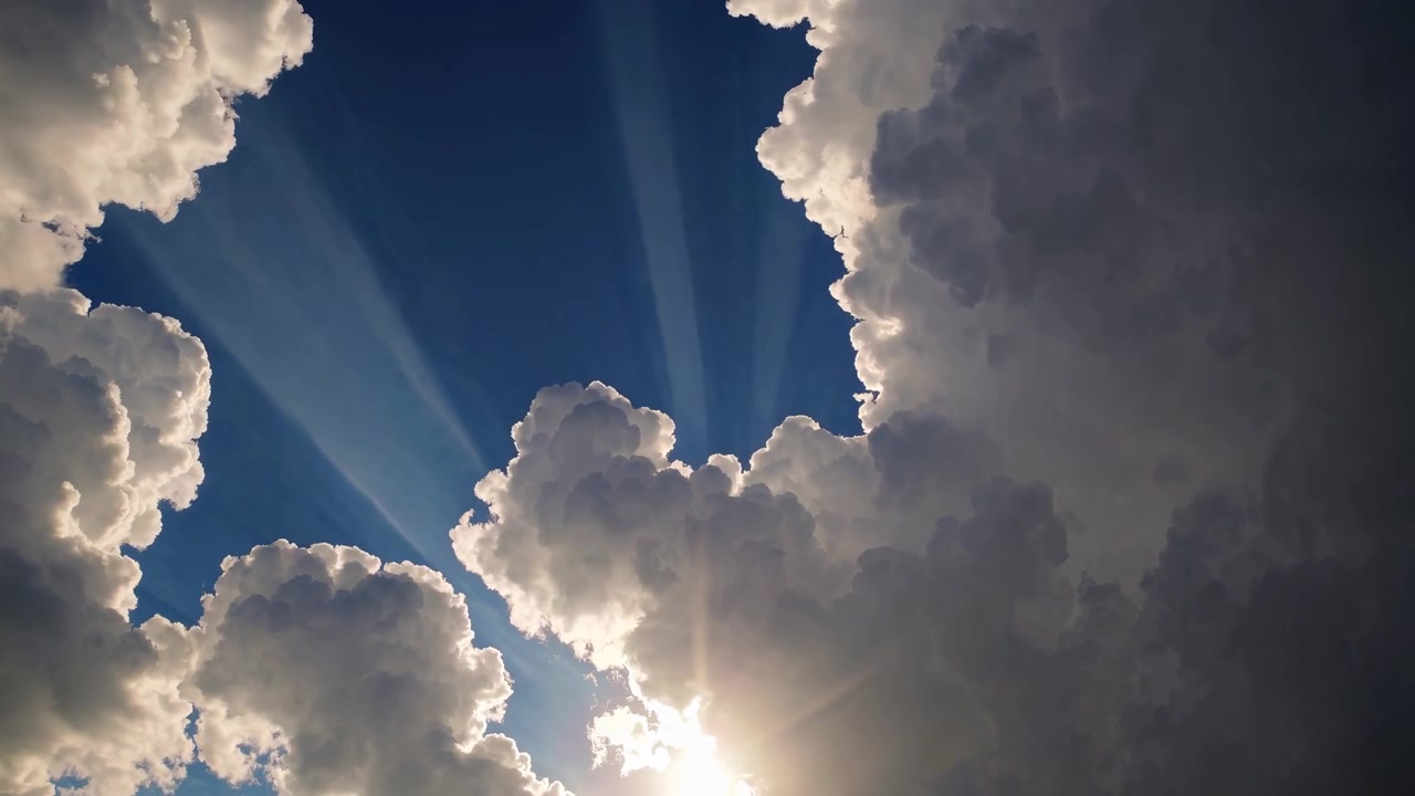 Raggi di sole che filtrano attraverso imponenti nuvole cumuliformi