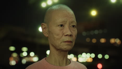 old-Asian-woman-in-city-at-night