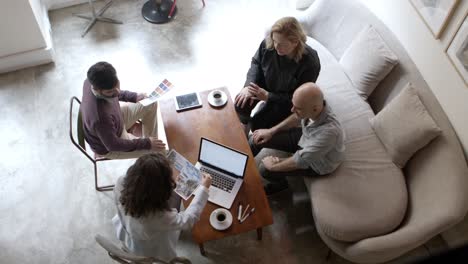 Top-view-of-two-architects-talking-with-clients-in-office