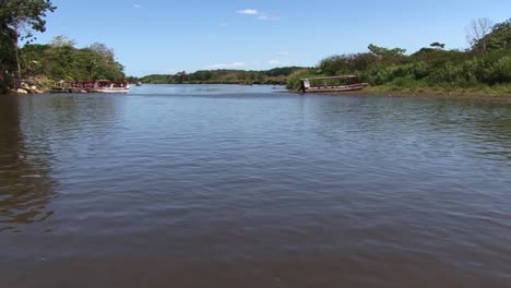 Wide-shot-of-Tarcoles-river-in-Costa-Rica-and-the-rain-forest-around,-boats-waiting-for-tourists-by-the-river-bank